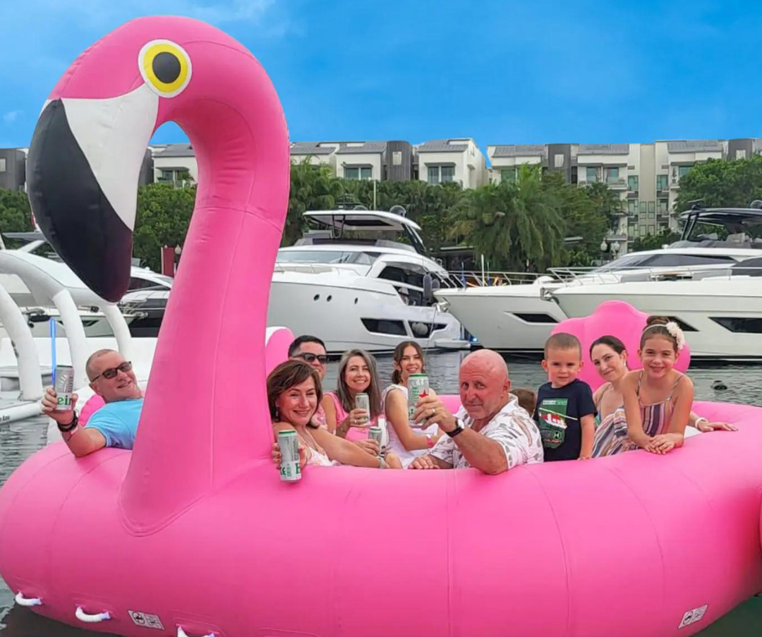 Structure gonflable rose en forme de flamant. Élément décoratif et ludique pour activités nautiques ou événements sur l’eau