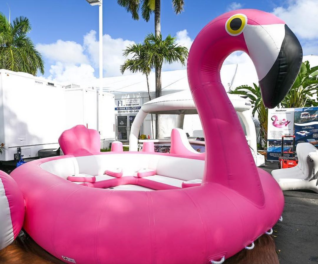 Structure gonflable rose en forme de flamant. Élément décoratif et ludique pour activités nautiques ou événements sur l’eau