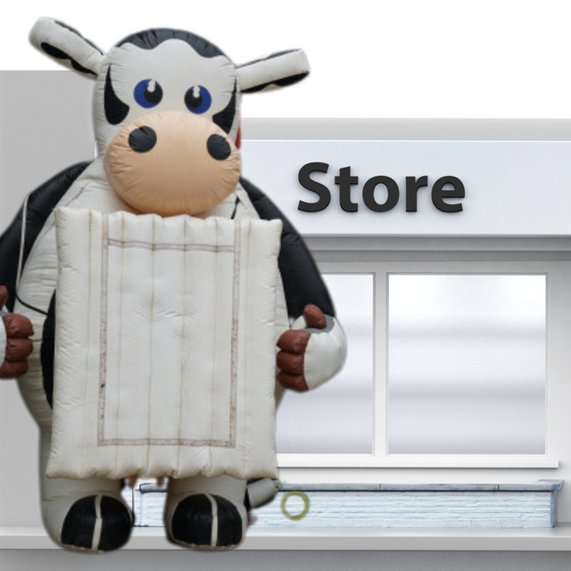 Structure gonflable en forme de vache avec panneau. Utilisée comme élément publicitaire pour événements ou points de vente

